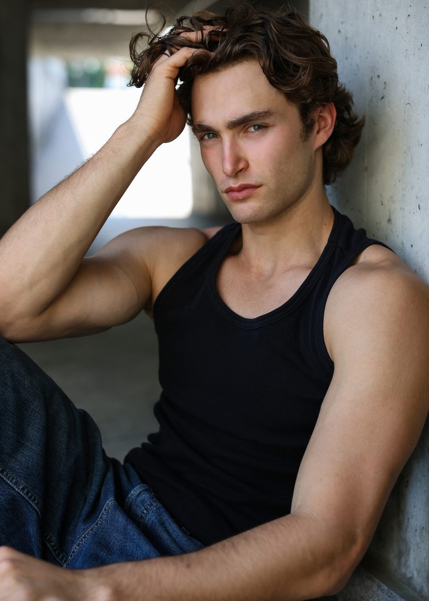 Pascal Sander in a black tank top, leaning against a concrete wall