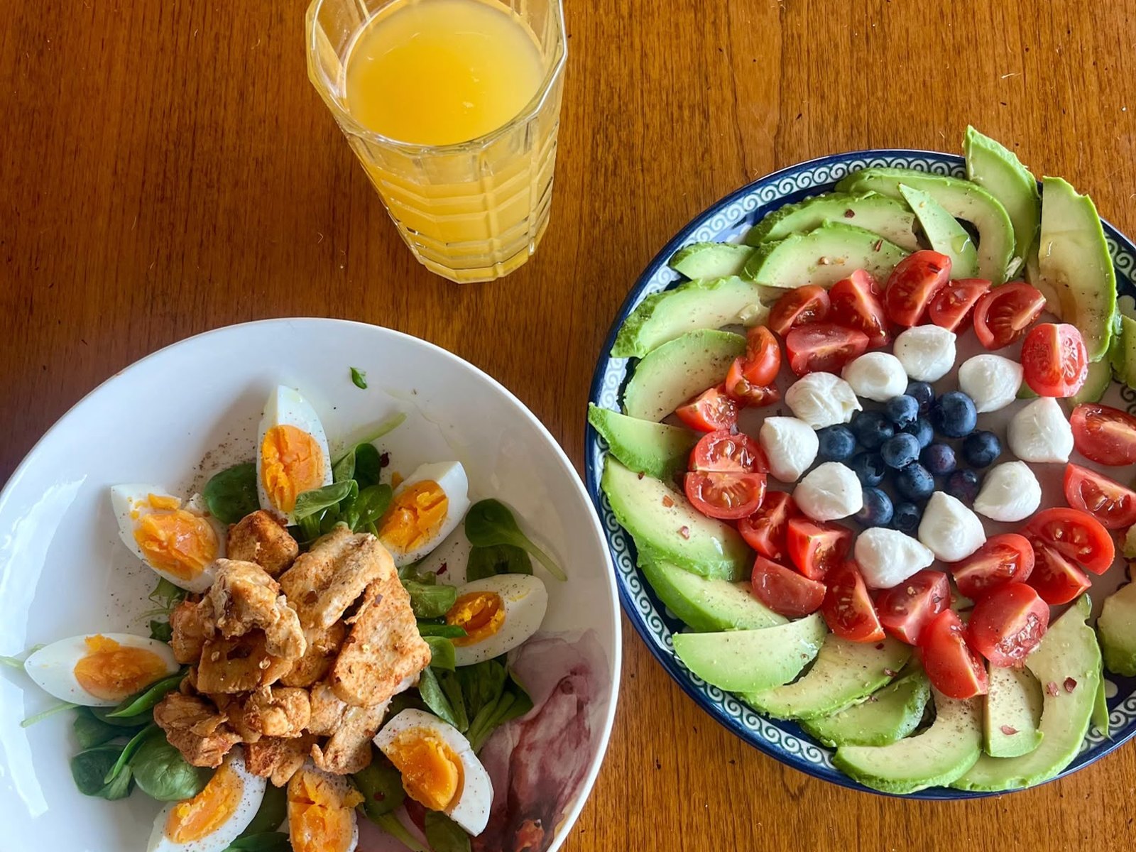 A chicken salad and avocado plate with orange juice