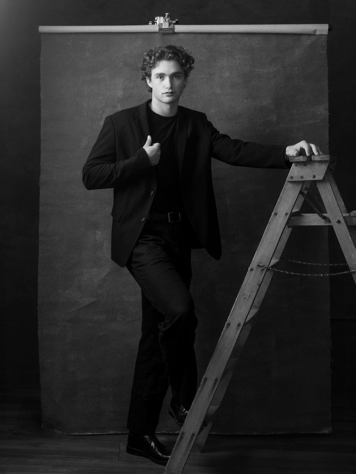 Pascal Sander, studio shoot leaning on a wooden ladder