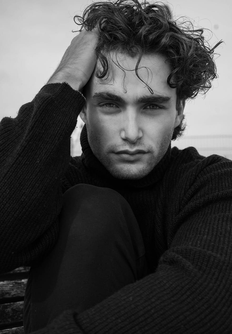 Pascal Sander with a hand in his hair, dark studio portrait