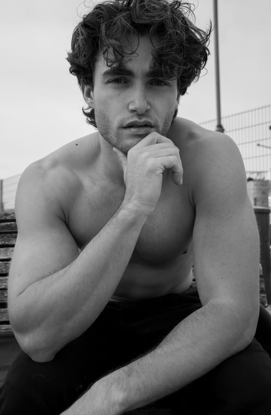 Pascal Sander shirtless at a harbour, hand to his chin