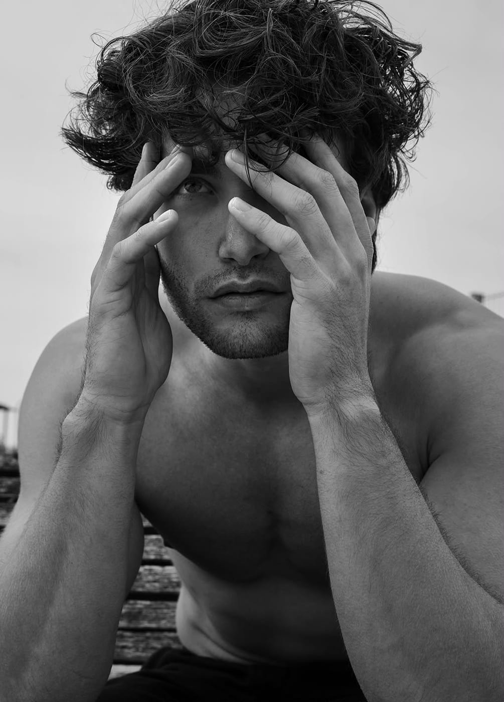 Pascal Sander shirtless, pushing back wet hair by the water