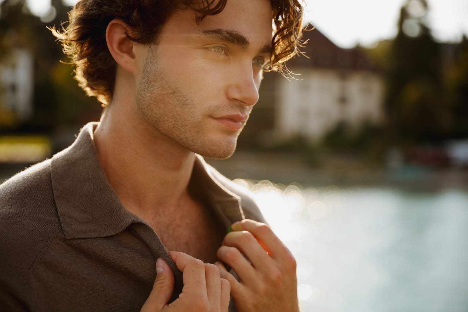 Pascal Sander in a brown polo by a lake at golden hour