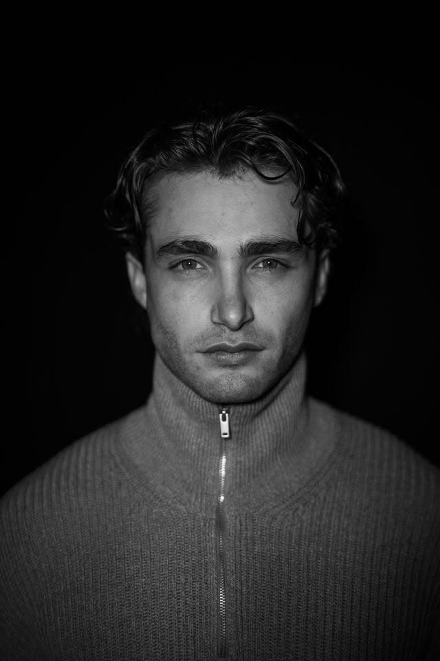 Pascal Sander in a ribbed sweater, dark studio portrait