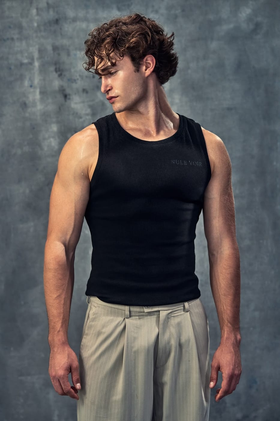 Pascal Sander in a black tank and beige trousers, studio