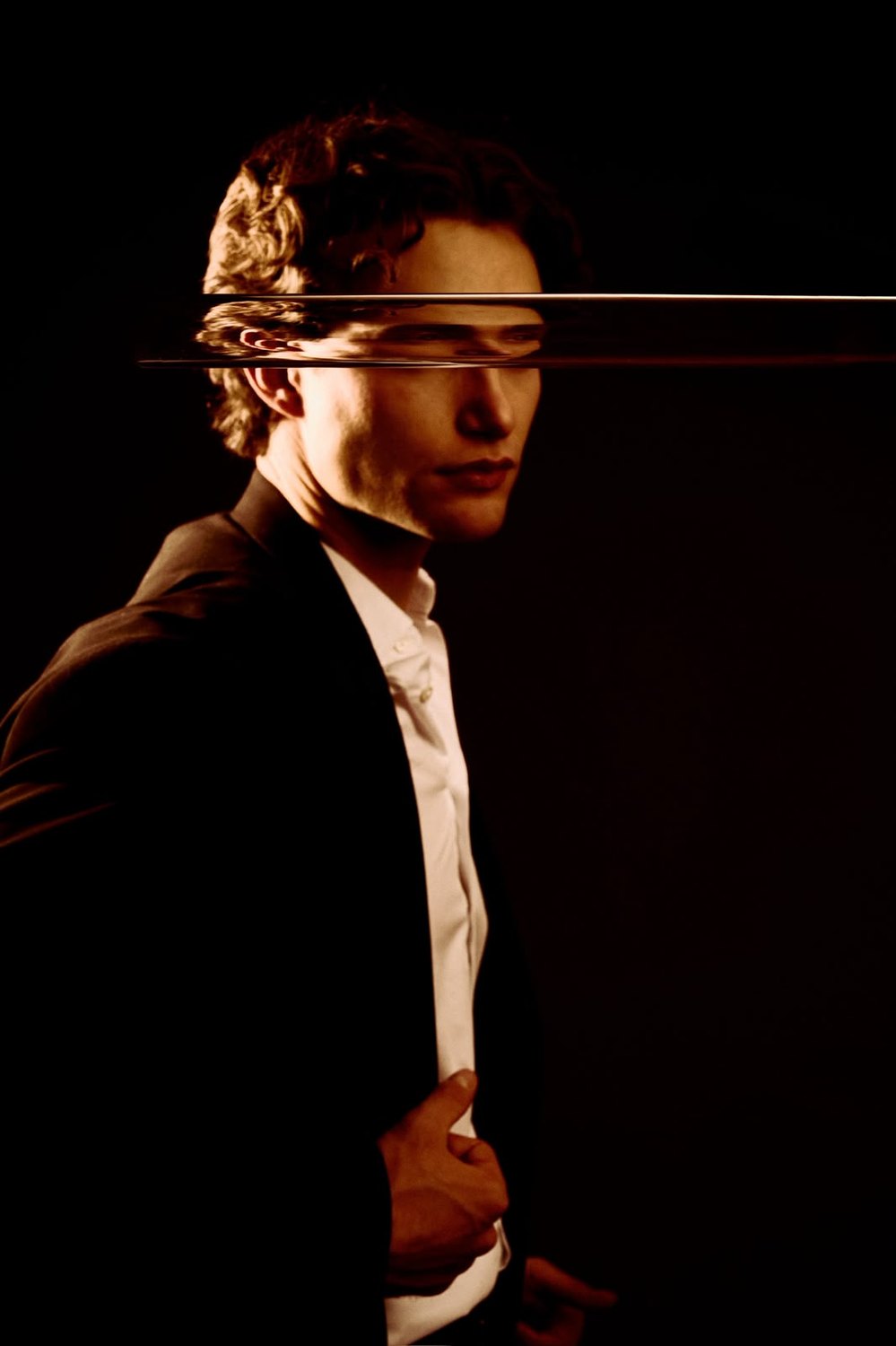 Pascal Sander in profile under warm light, dramatic studio