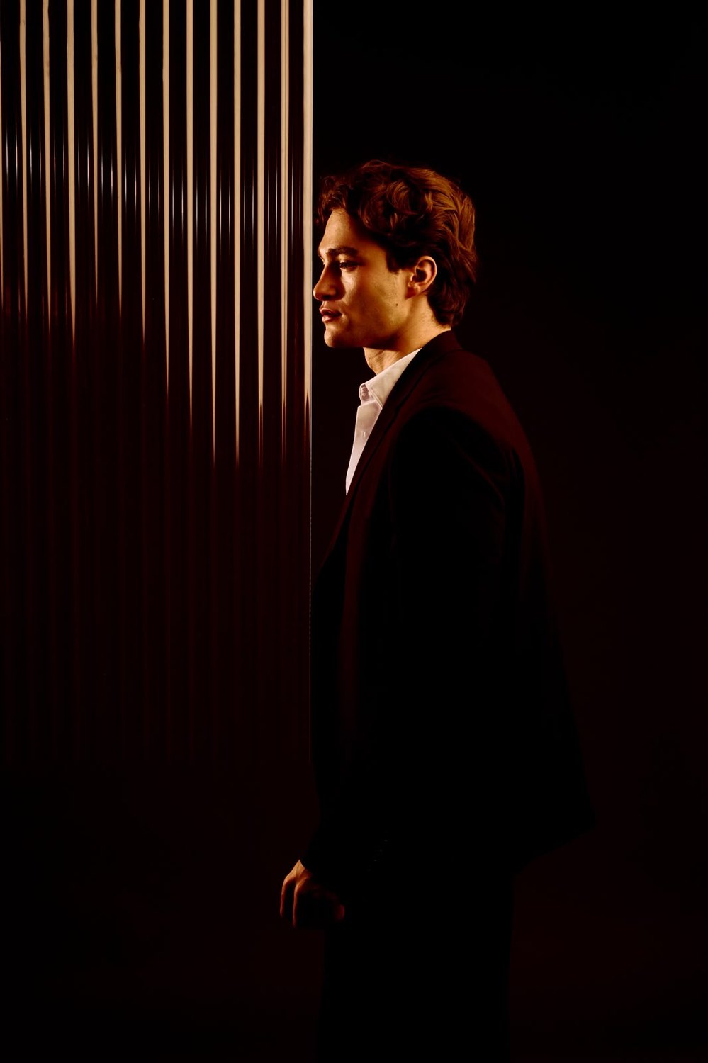 Pascal Sander in silhouette beside a lit panel