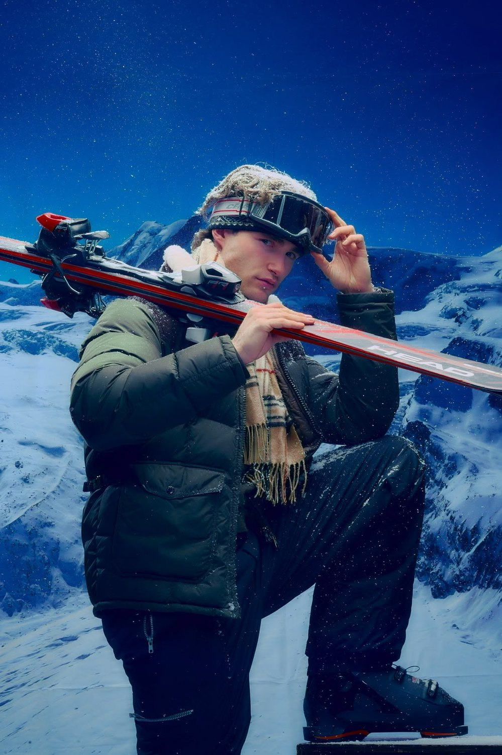 Pascal Sander skiing, skis over his shoulder in the mountains