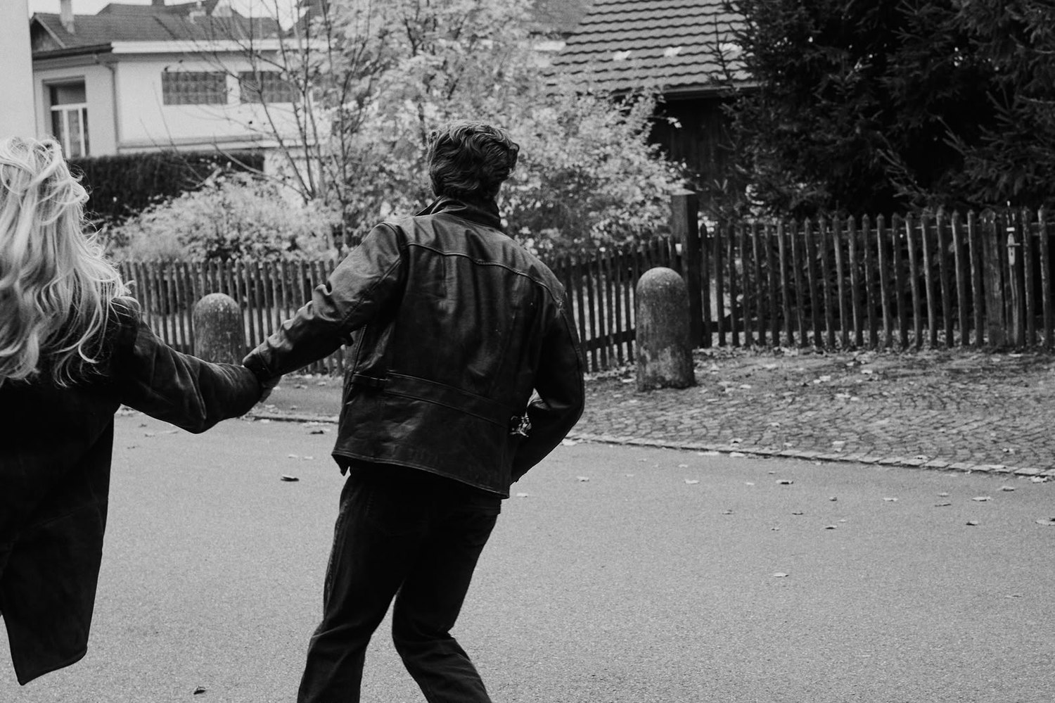 Pascal Sander and a partner running down a street, black and white