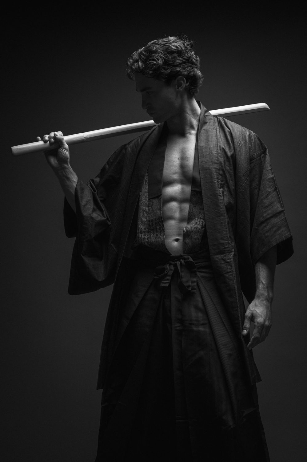 Pascal Sander in einem Kimono mit einem Holzschwert über der Schulter, Schwarz-Weiss